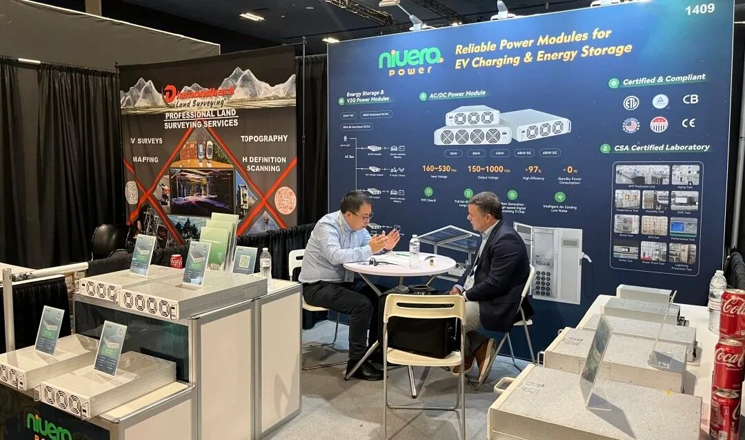 Reunião de negócios à mesa no estande durante a EV Charging Summit & Expo