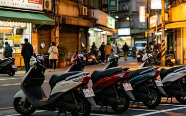 Motos e scooters estacionadas em fila em uma rua comercial movimentada