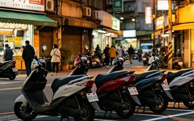 Motos e scooters estacionadas em fila em uma rua comercial movimentada