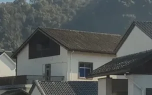 Casas em uma área rural, junto a uma encosta com vegetação