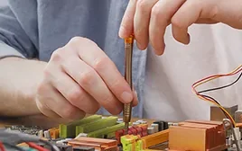 Técnico montando componentes em uma placa eletrônica