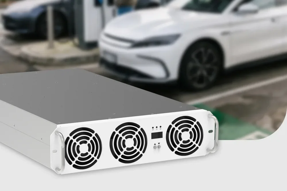 Módulo de potência AC/DC V2G de 22 kW, com três ventiladores, diante de uma estação de recarga e de um veículo elétrico